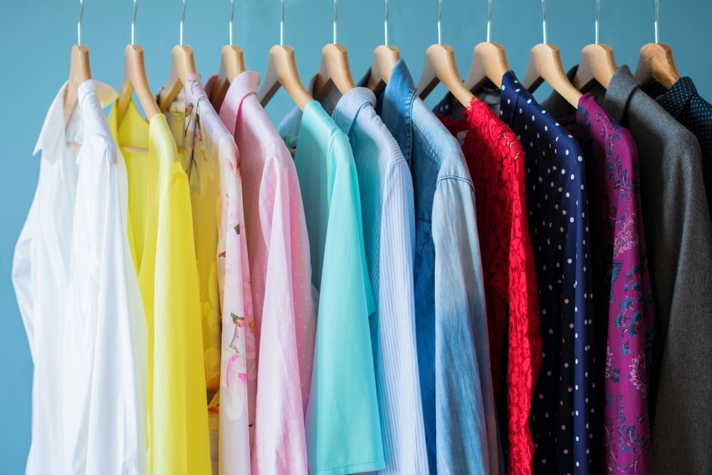 multicolored and clothes lined up and organized on hangers
