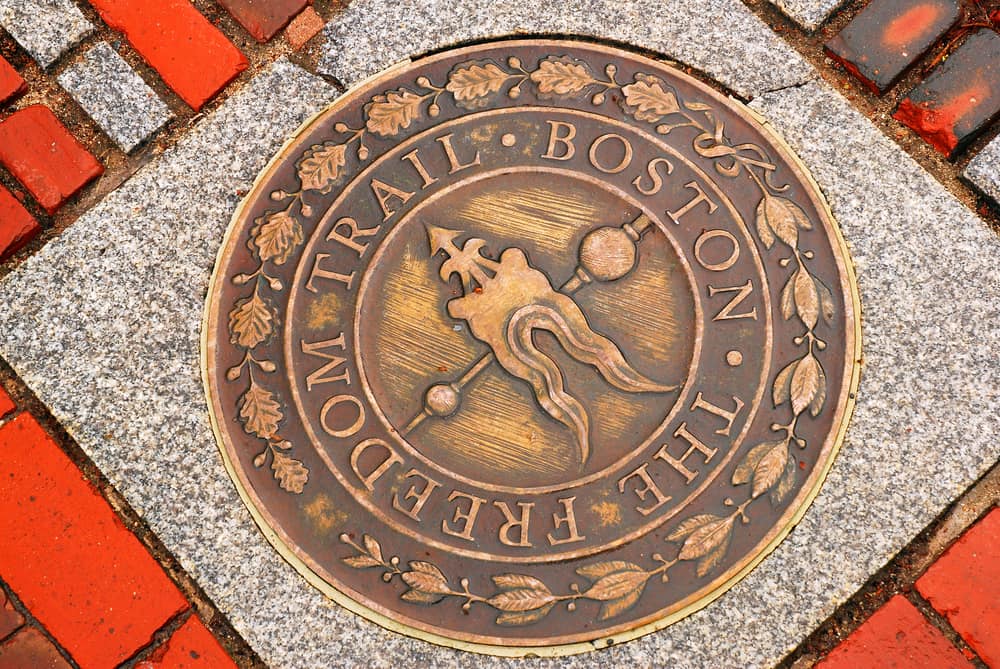 The Boston Freedom Trail symbol in bronze on the ground surrounded by red bricks