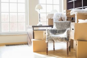 furniture in bubble wrap and packed boxes inside an apartment