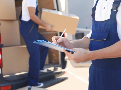 moving companies in Los Angeles with movers holding clipboard and holding a box