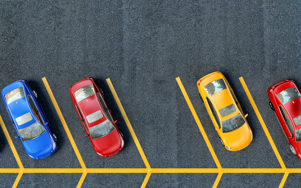 parking lot view from above with blue yellow and red cars