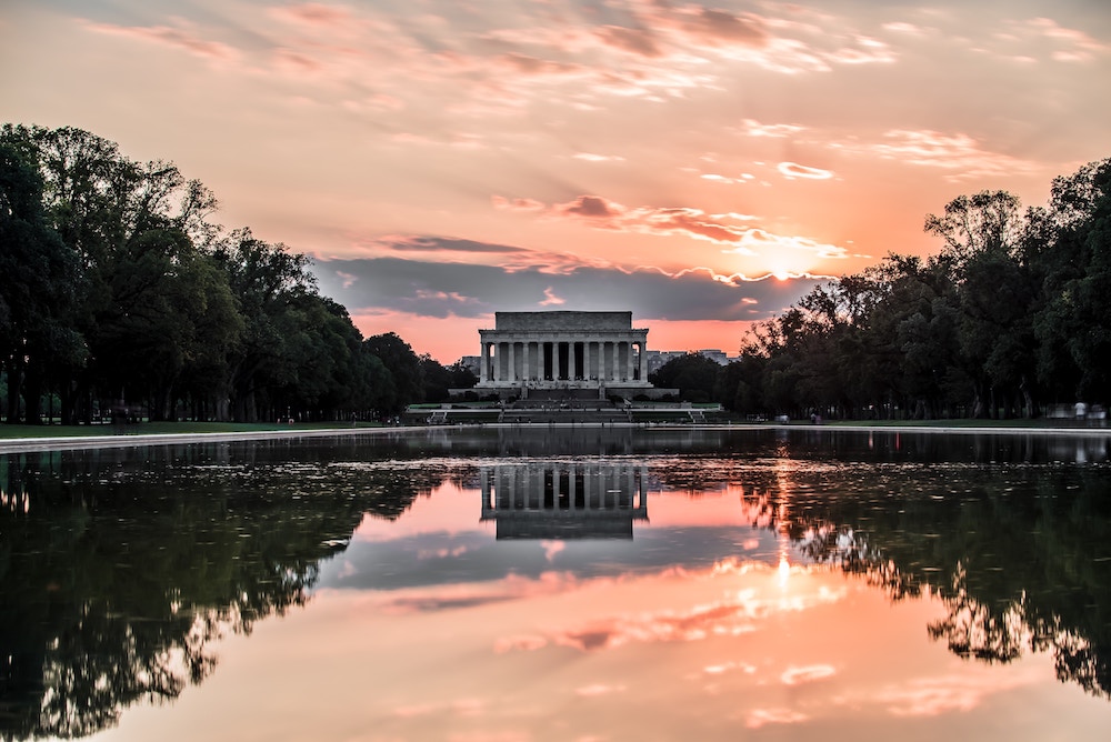 The Lincoln Memorial in D.C. at sunset in front of a long reflecting pool