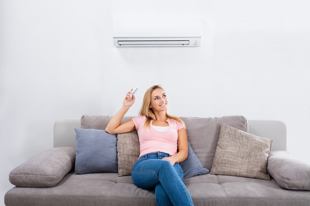 woman sitting on couch opening the AC