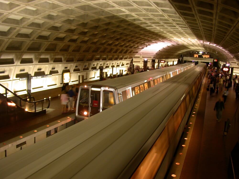 two trains and lots of commuters standing around in a Washington, D.C. metro station