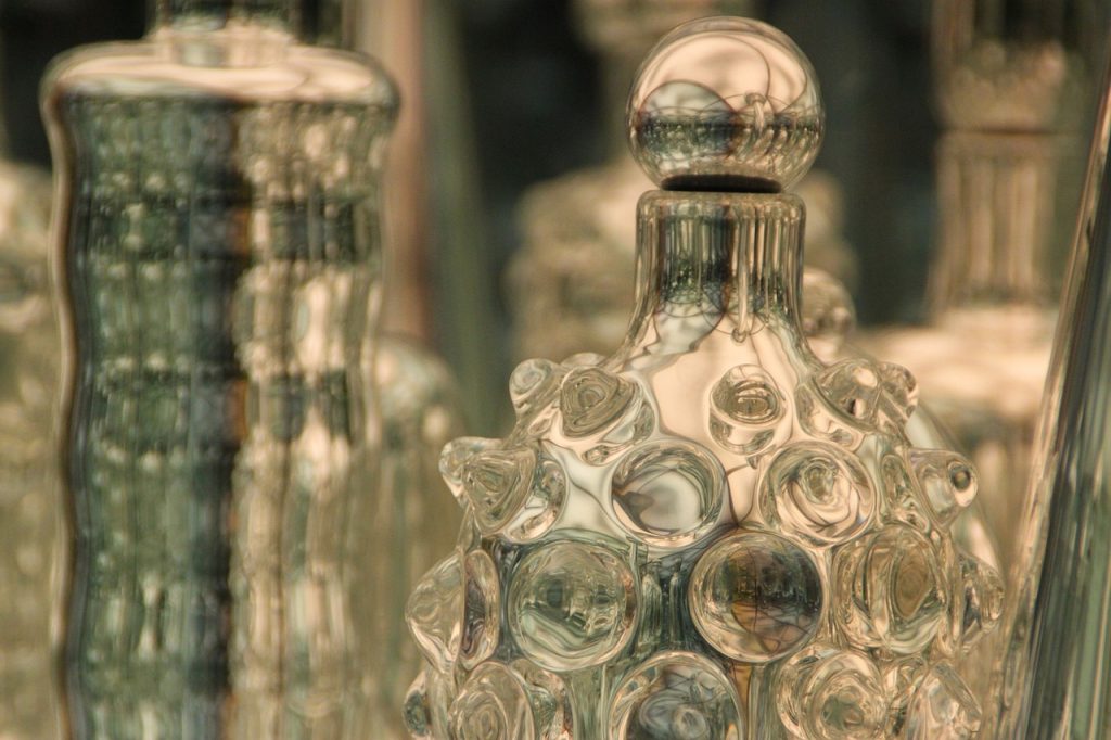 A close up shot of empty glass bottles that are all intricately designed and placed next to each other 