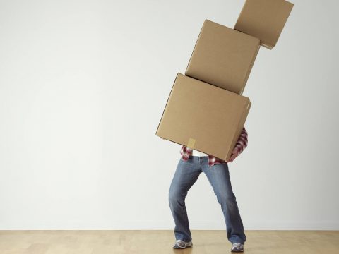 best moving companies in Boston a man struggling to carry a pile of boxes