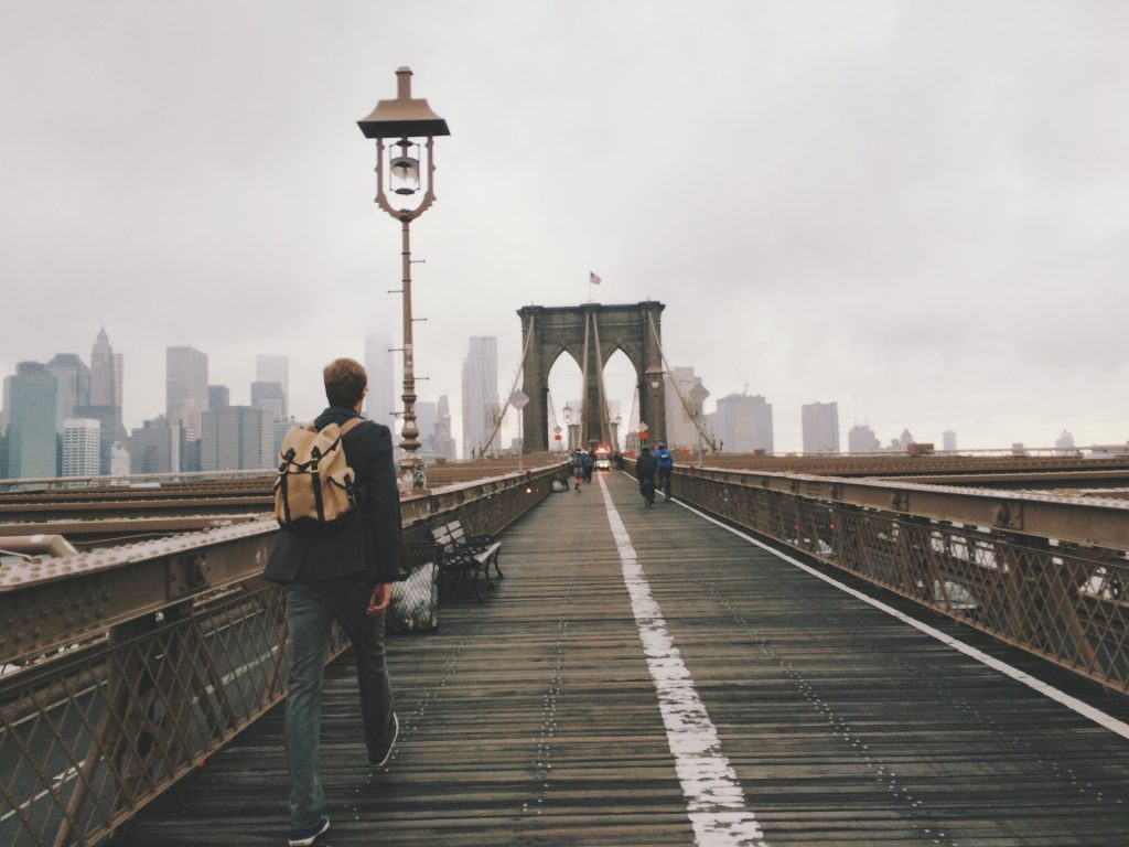 extended stay hotel NYC a man walking across the brooklyn bridge on a misty day