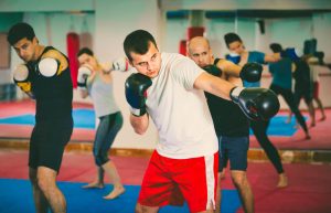 a group practicing a jab punch in a boxing class