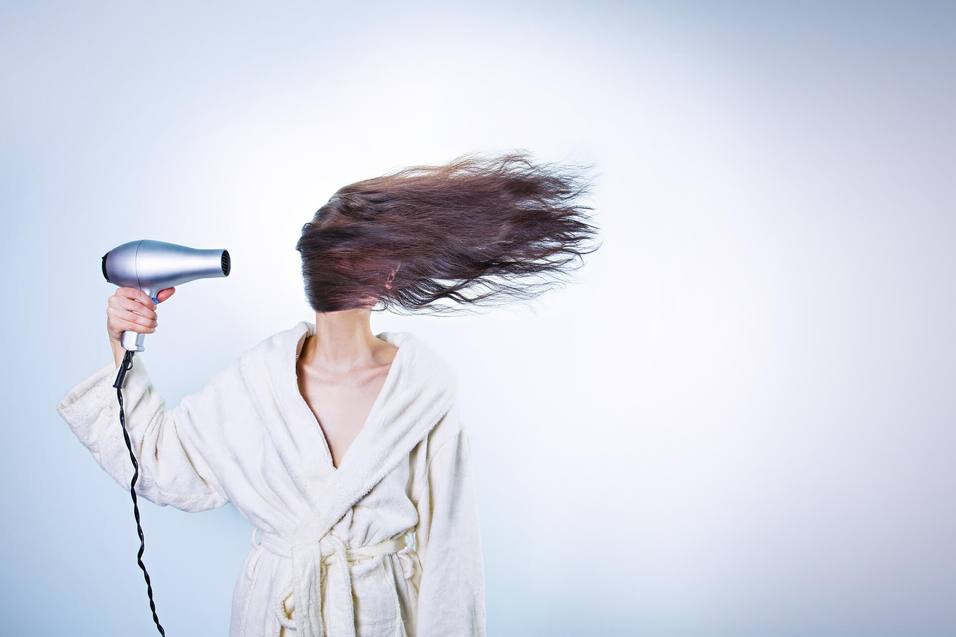 a woman blow-drying her hair
