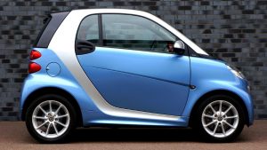 blue and white smart car for two available by Car2Go company
