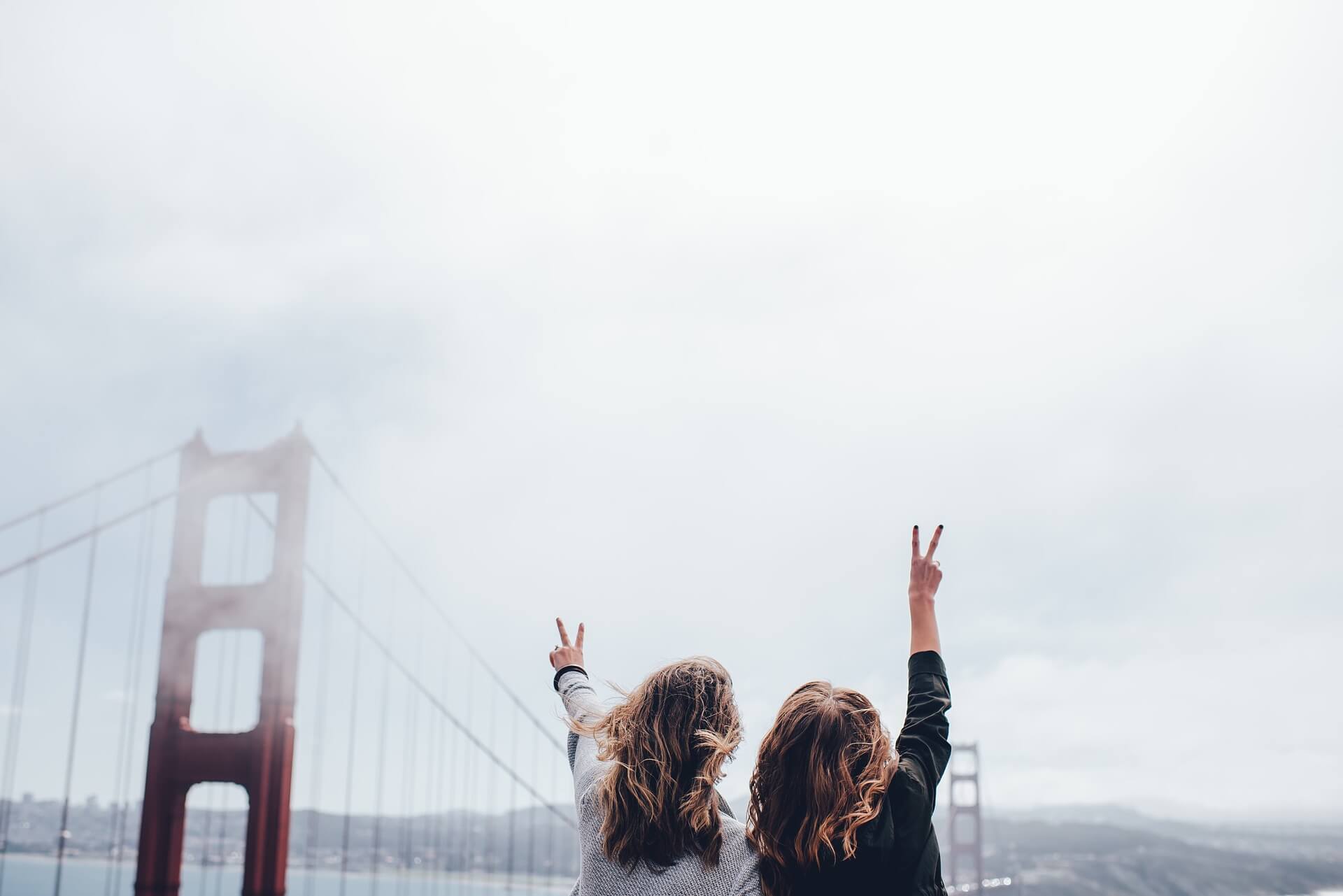 hidden gems San Francisco two girls making a peace sign in front of the golden gate bridge