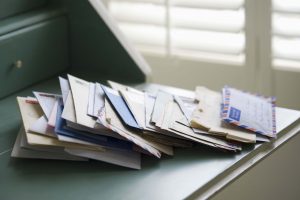 a pile of letters and mail sitting on a desk