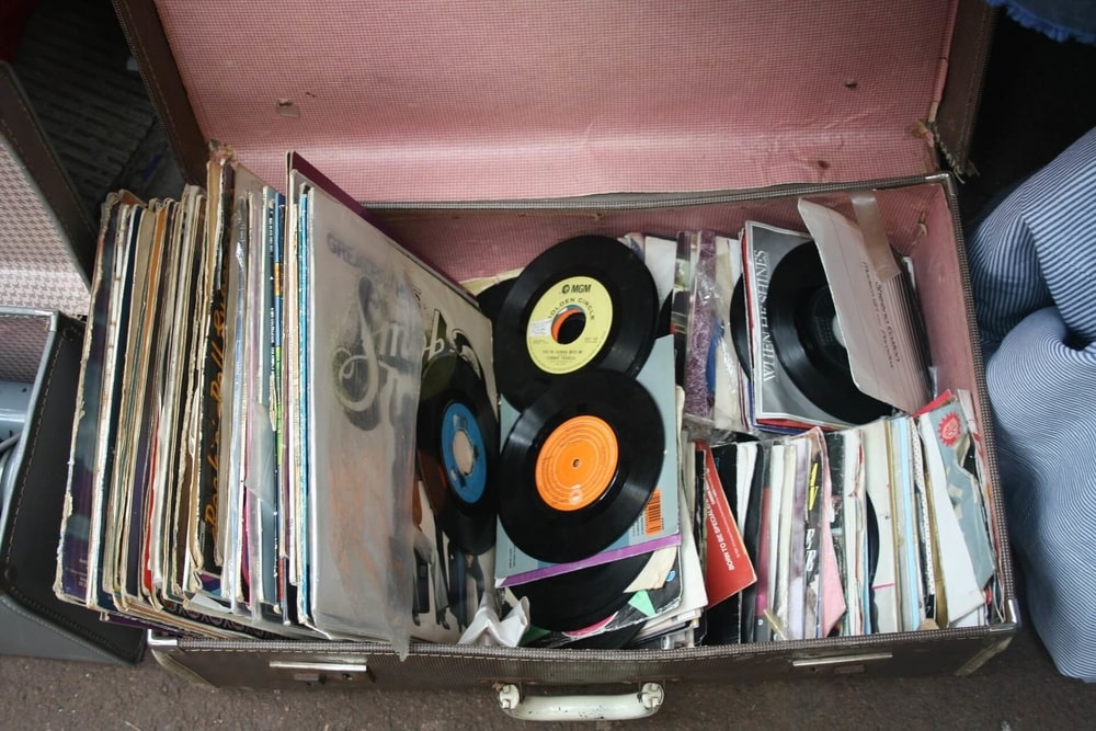 an old black suitcase full of old and used records 