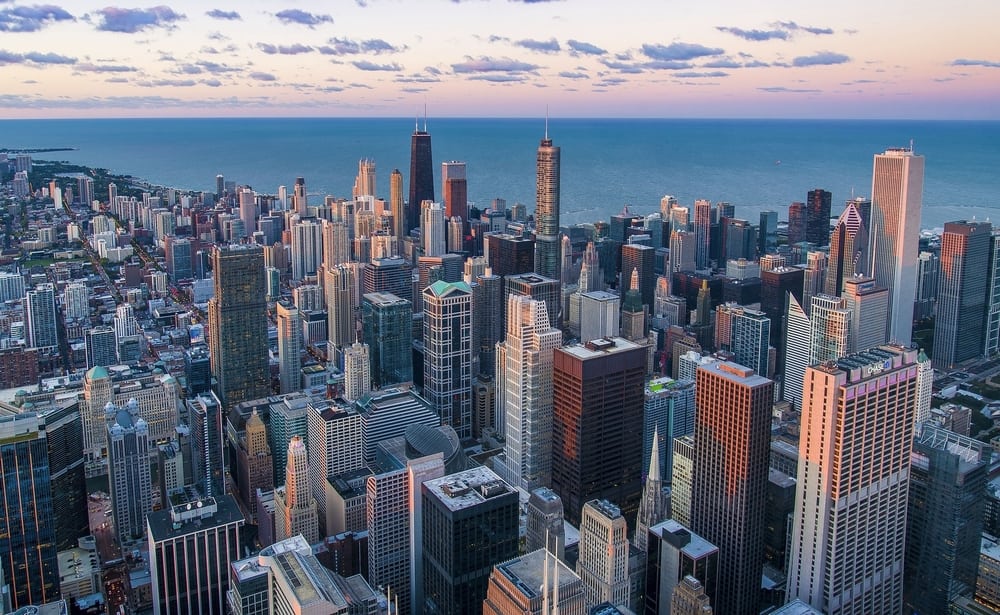 birds eye view of the city of Chicago with the water in the background and lots of tall buildings in the foreground