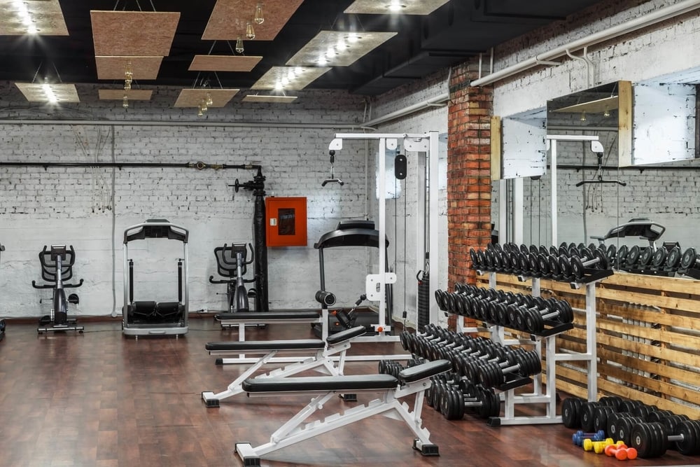 gyms in DC rack of dumbbells against a mirror with weight benches and treadmills