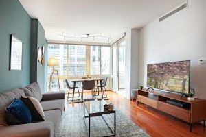 housing in DC interior of apartment living space with couch television dining table and floor to ceiling windows