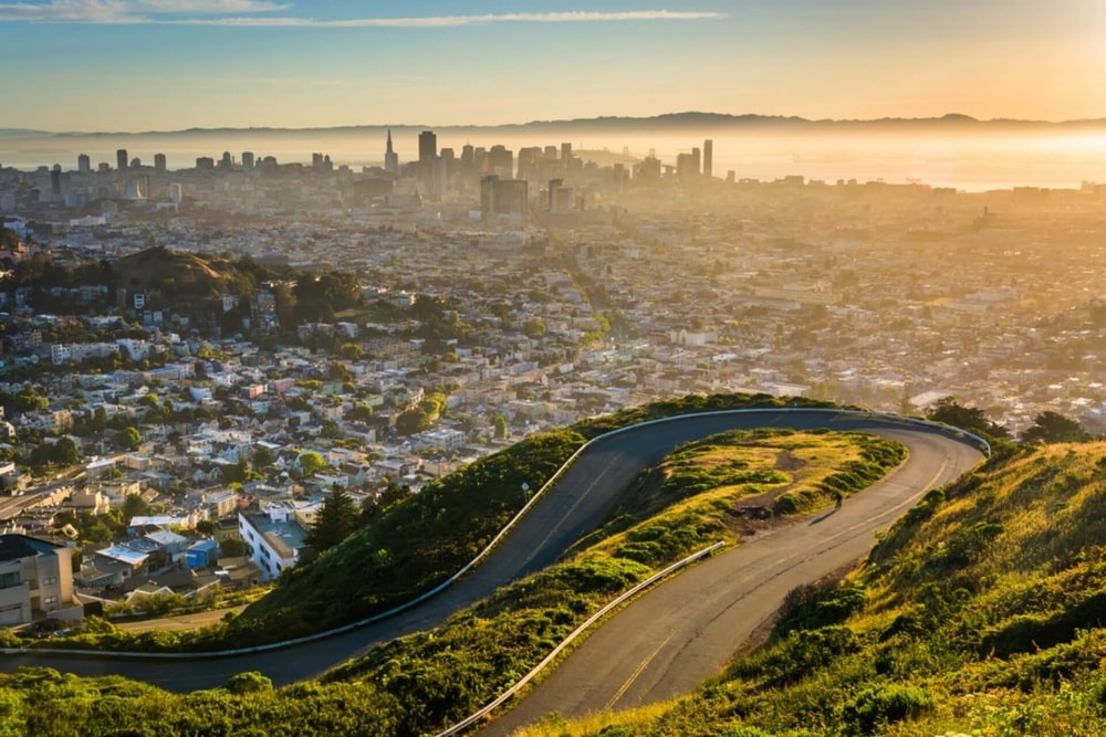 a view of San Francisco from the top of a hill at dusk