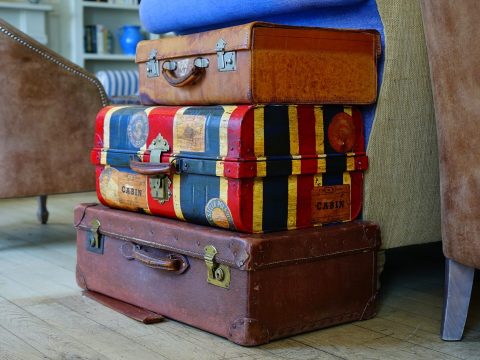 luggage shipping three different colored suitcases stacked on top of each other
