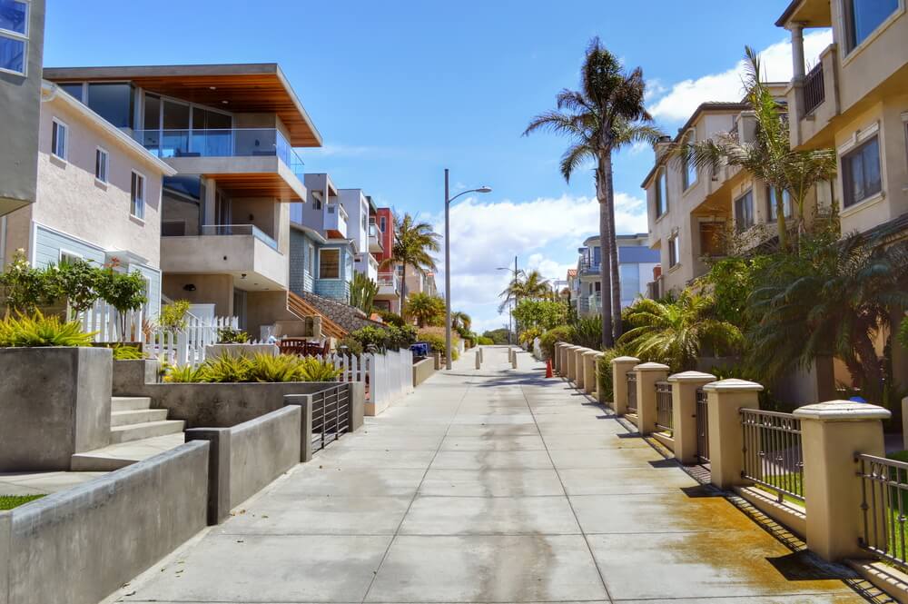A pathway between rows of houses to walk down to the ocean in the Manhattan Beach neighborhood of Los Angeles California