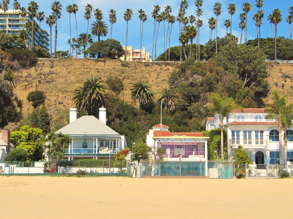 Los Angeles houses on the beach with palm trees lined in the background