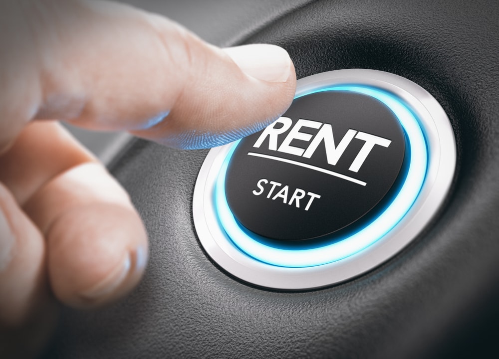 person pushing start button with word rent concept of car rental