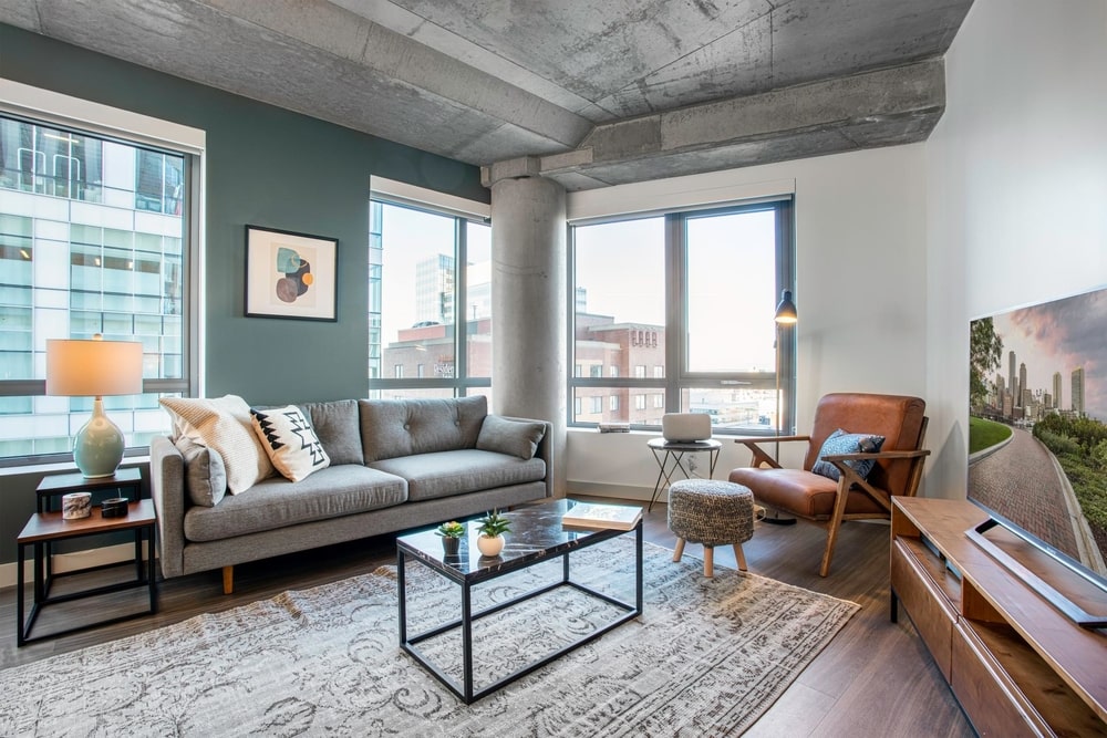 blueprint blueground one bedroom apartment Boston living space with cement ceiling and dark marble table