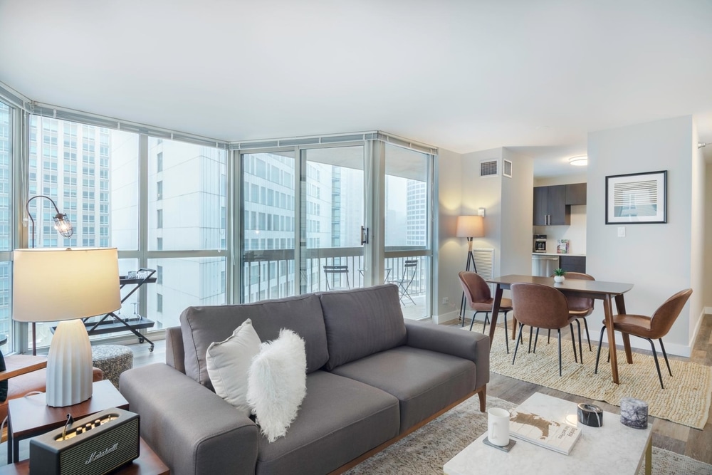 short term rental chicago beautiful studio wall to ceiling windows beautiful open space living room wall to ceiling windows blue couch in front of white table