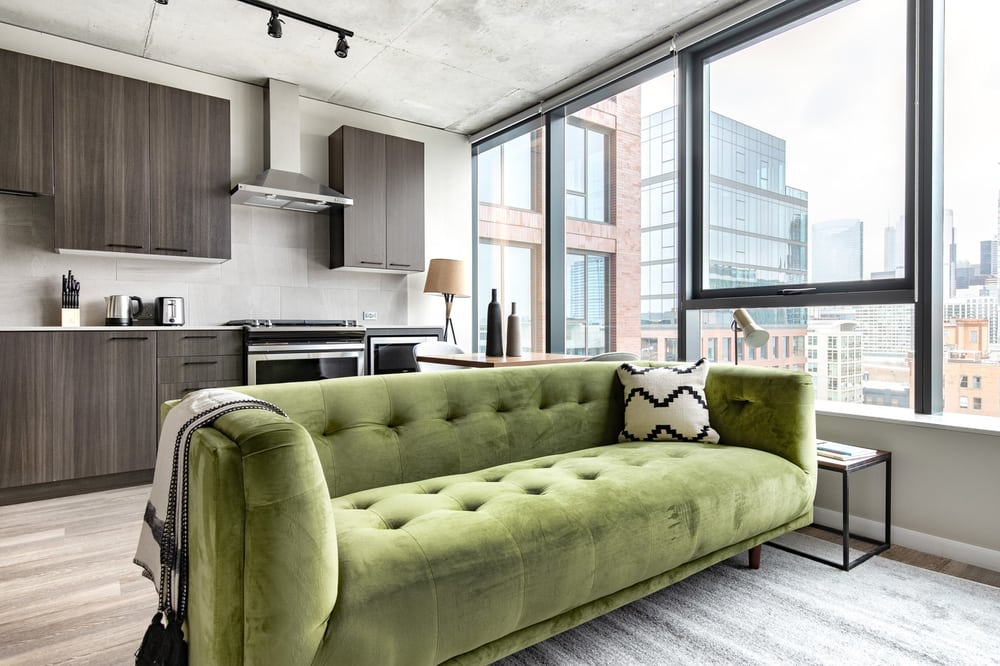 green velvet sofa with kitchen in background