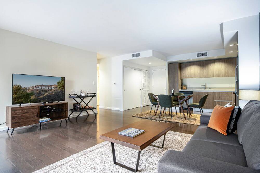 A large spacious furnished living room in Los Angeles. There is a couch and a coffee table across from a TV and TV stand