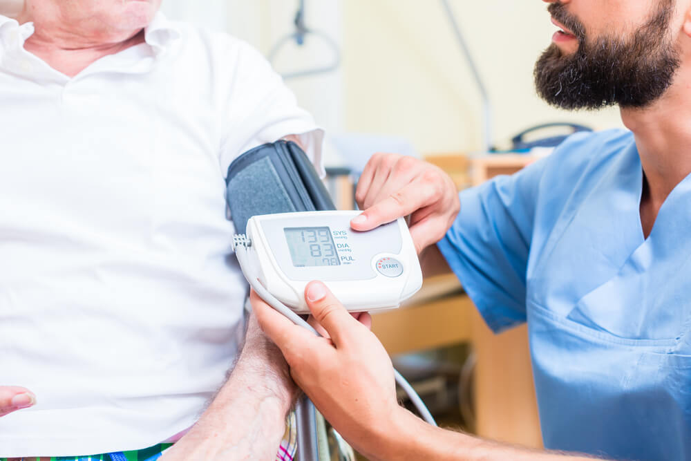 travel nurse taking patient's blood pressure reading