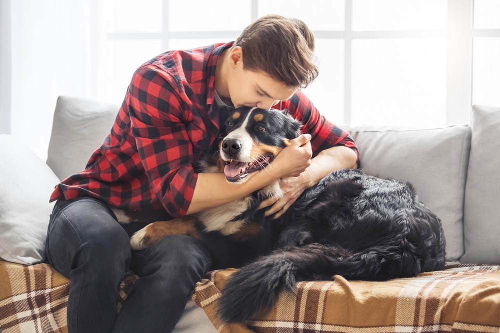 a young man kissing his dog on the head in his pet-friendly Seattle apartment