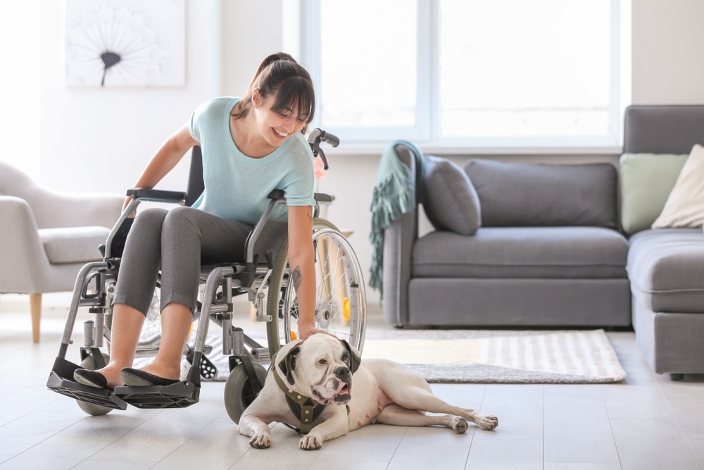 woman on a wheelchair petting her dog in her pet-friendly Seattle apartment