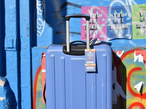 blue stasher suitcase against graffiti wall