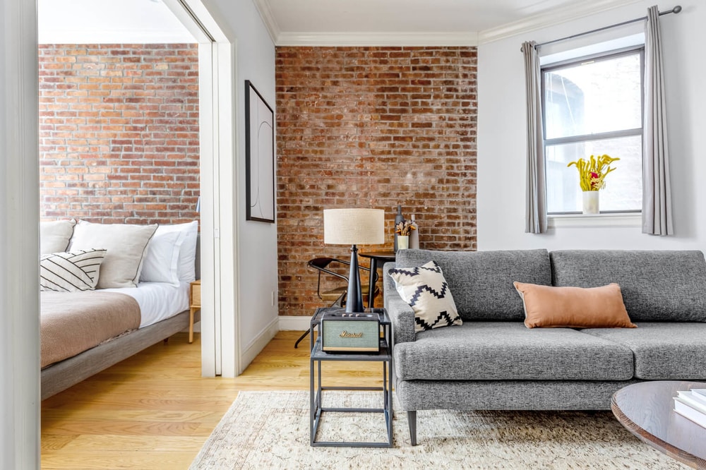 blueground apartment in New York City with exposed brick, view of cute bedroom and calm living room