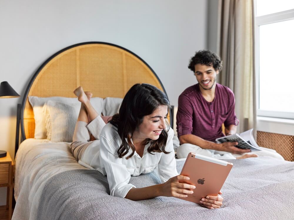 couple ordering online from bed with an iPad