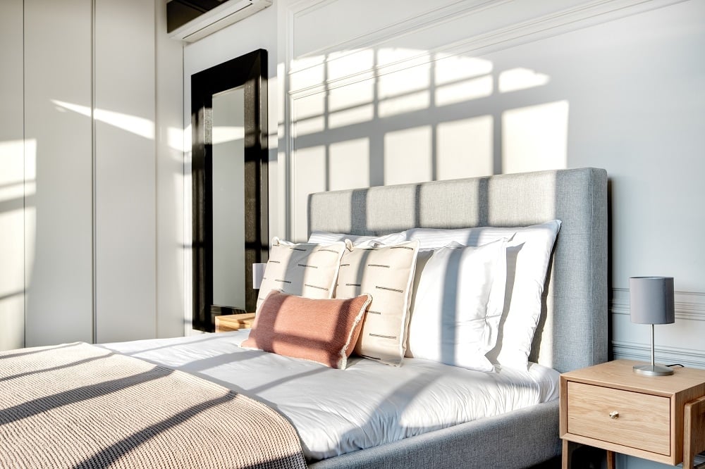 king bed with tufted headboard in evening sun
