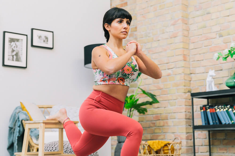 a woman completes an 8fit workout in a blueground apartment