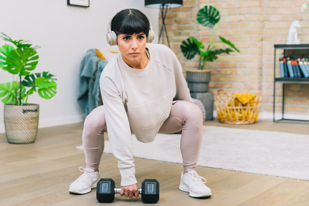 a woman completes an 8fit workout in a blueground apartment