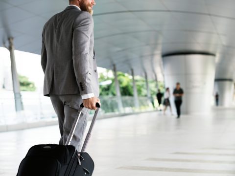 Businessman holding luggage on business trip