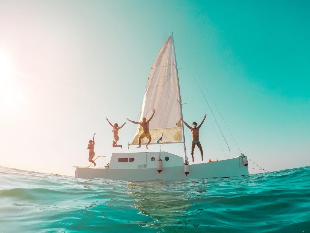 Friends jumping off sailboat
