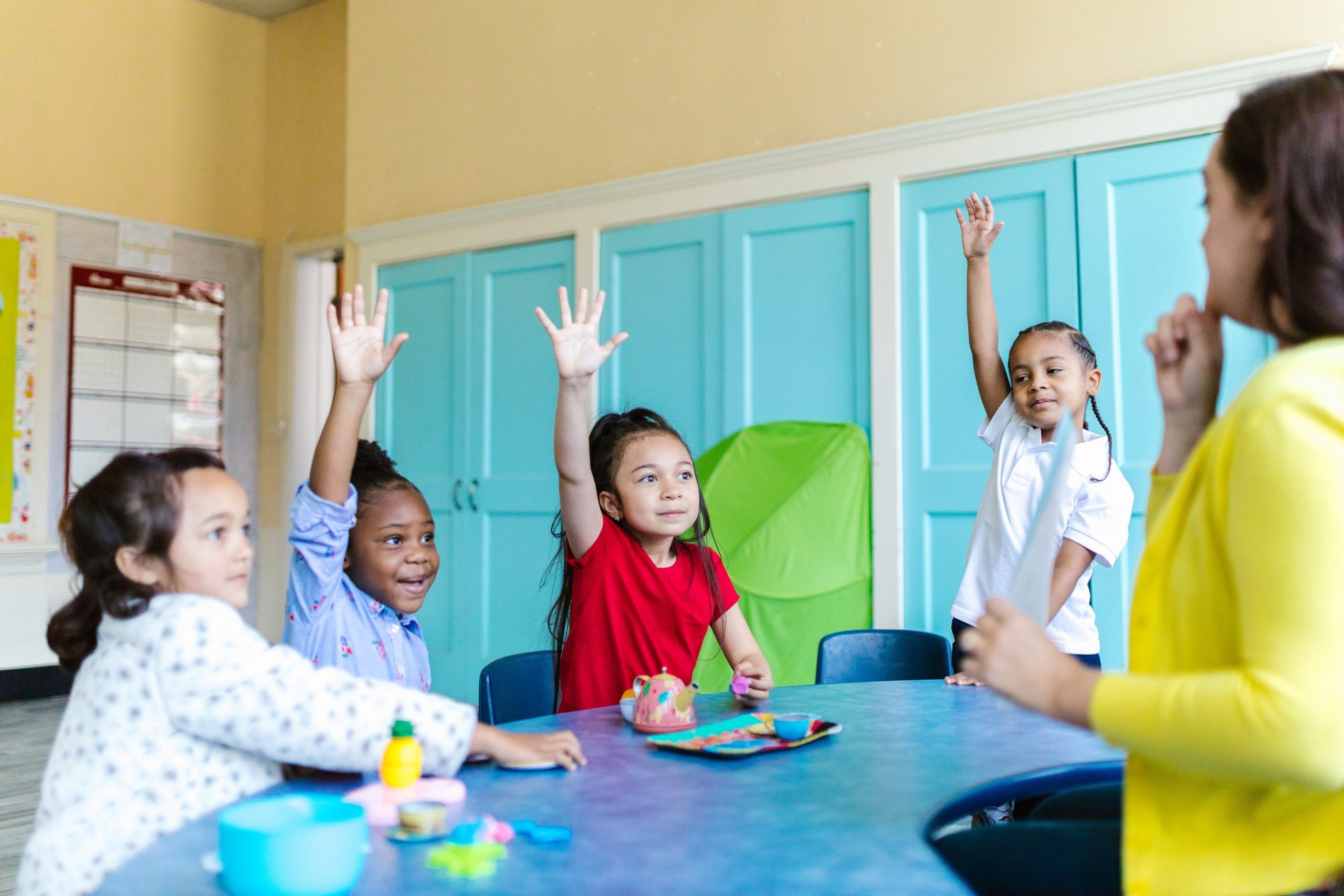 Children raising hands in international school